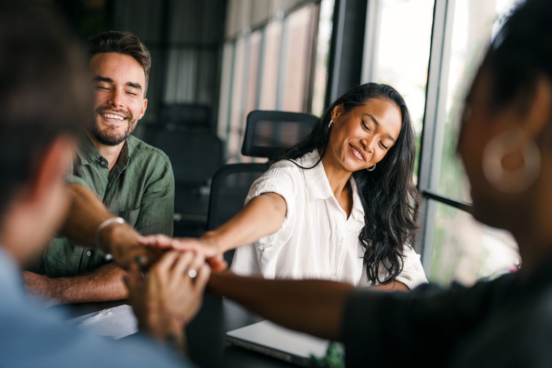Diverse group of business people's hands showing unity and teamwork. Business people's hands of different ethnicity coming together in a display of teamwork and unity. Diverse hands for teamwork