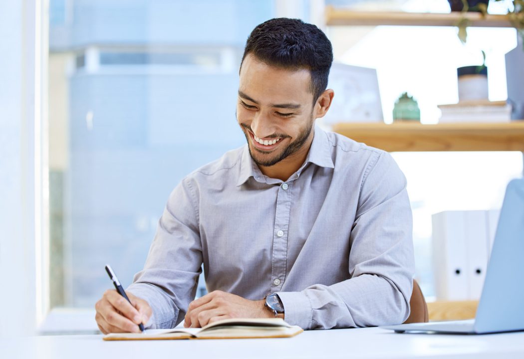 Shot of a businessman making notes while sitting at his desk.
